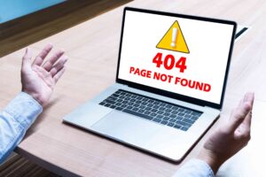businessman-spread-out-hands-with-attention-icon-message-404-page-found-display-laptop